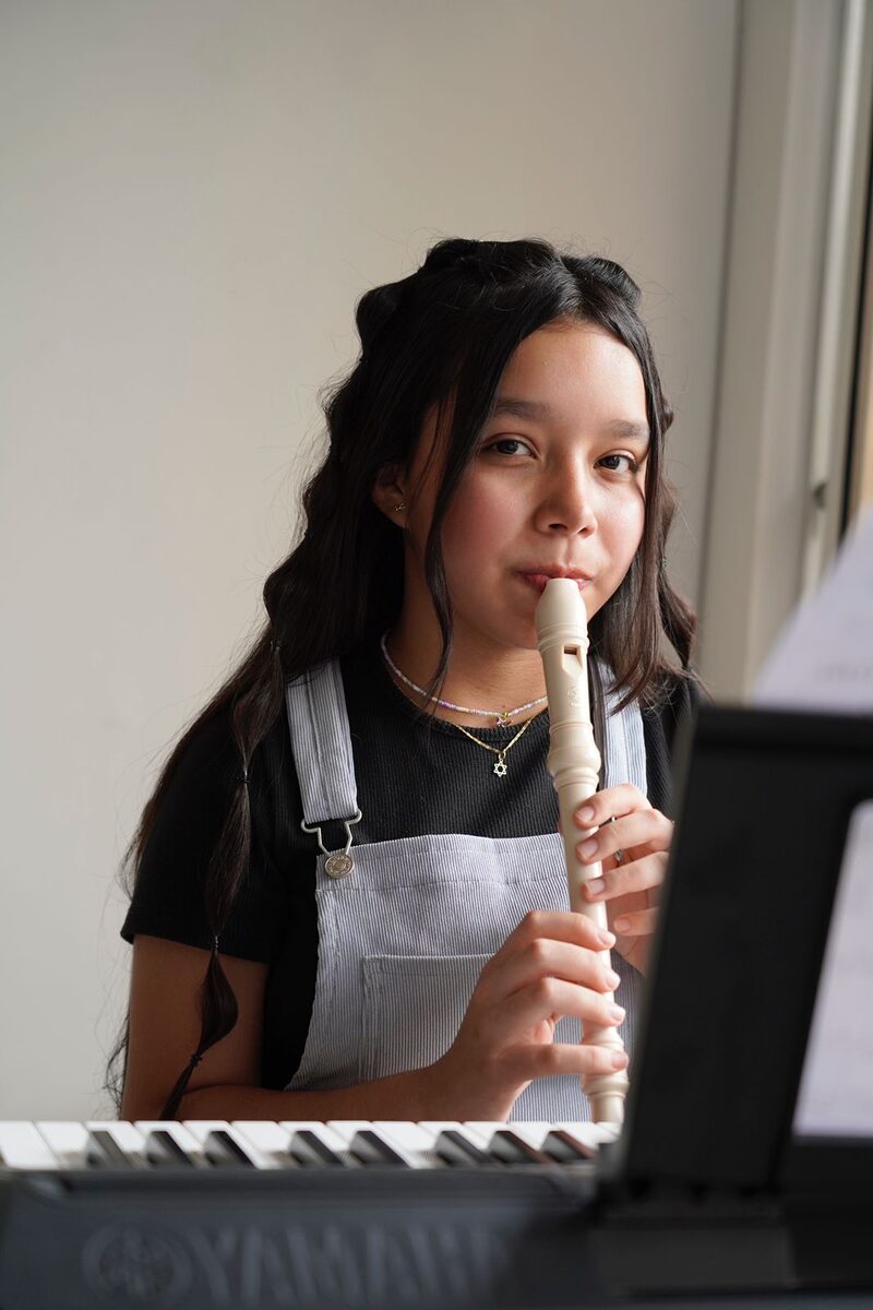 Estudiante tocando flauta dulce