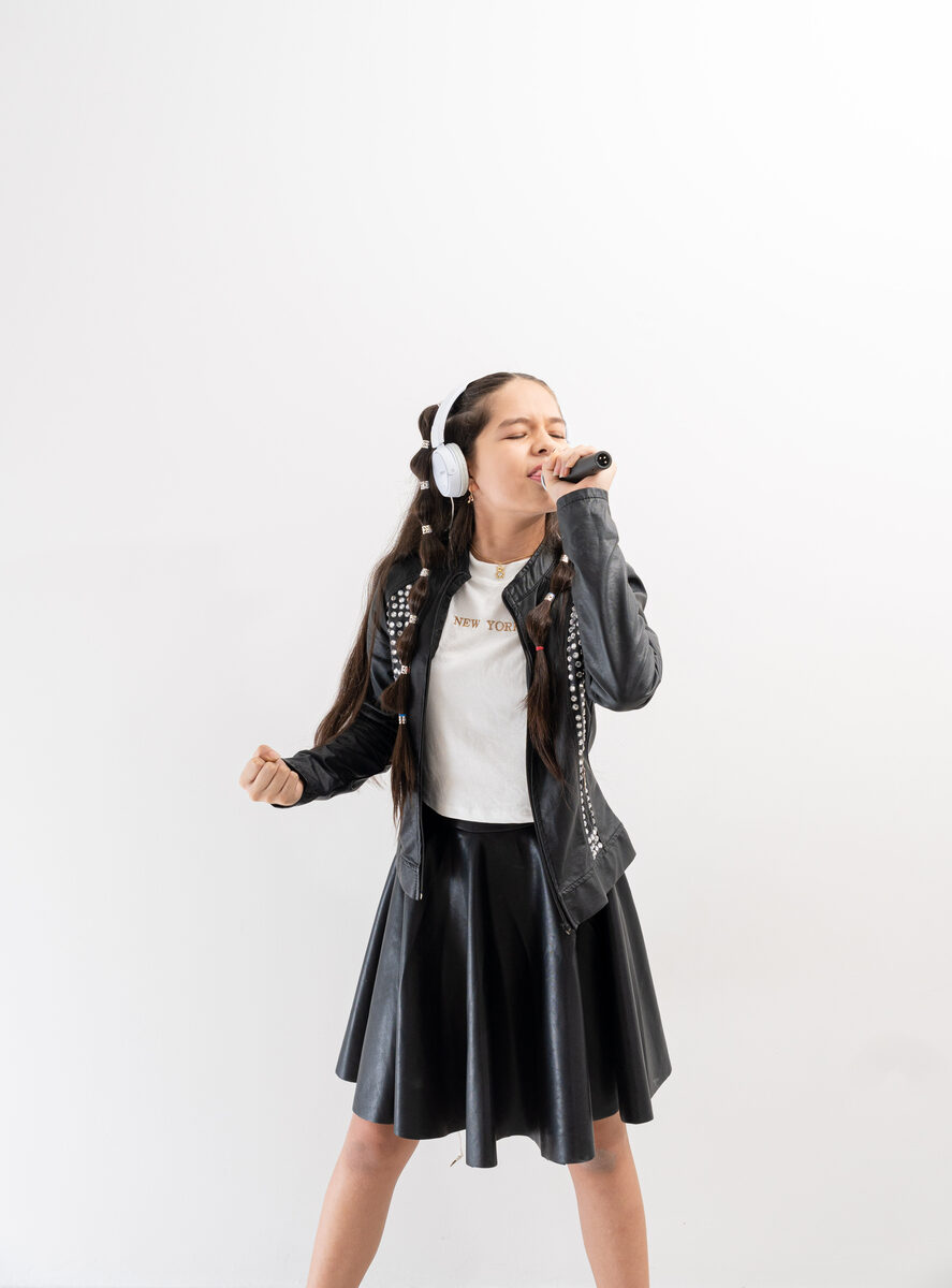 Niña haciendo split con micrófono